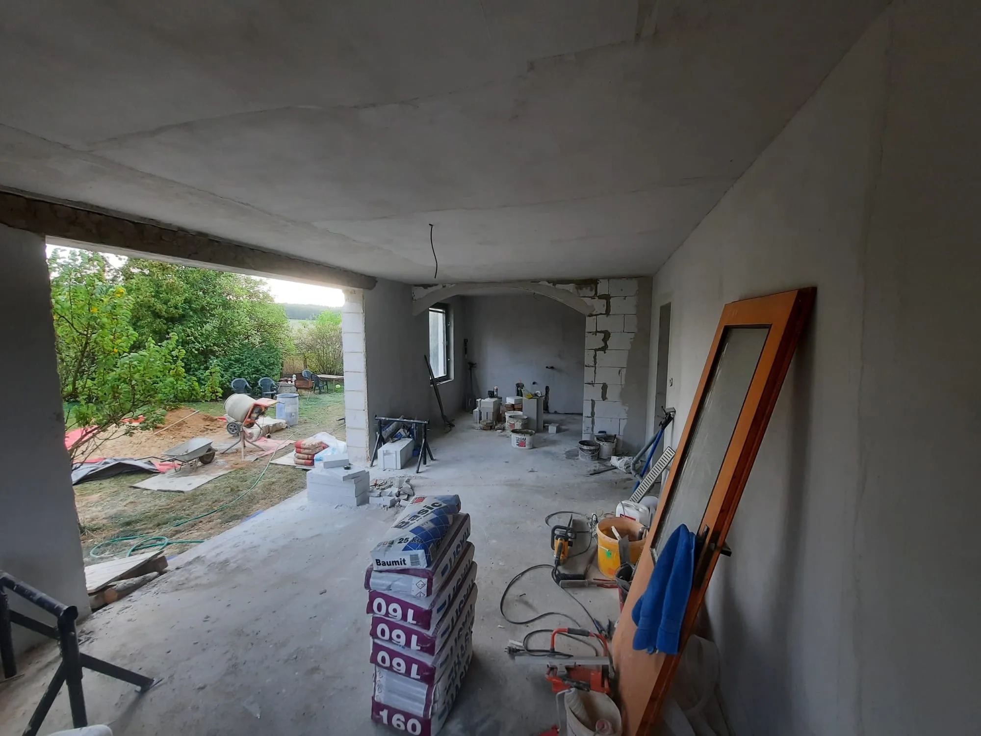 Omítnutá místnost s&nbsp;otvorem na terasu, během prací