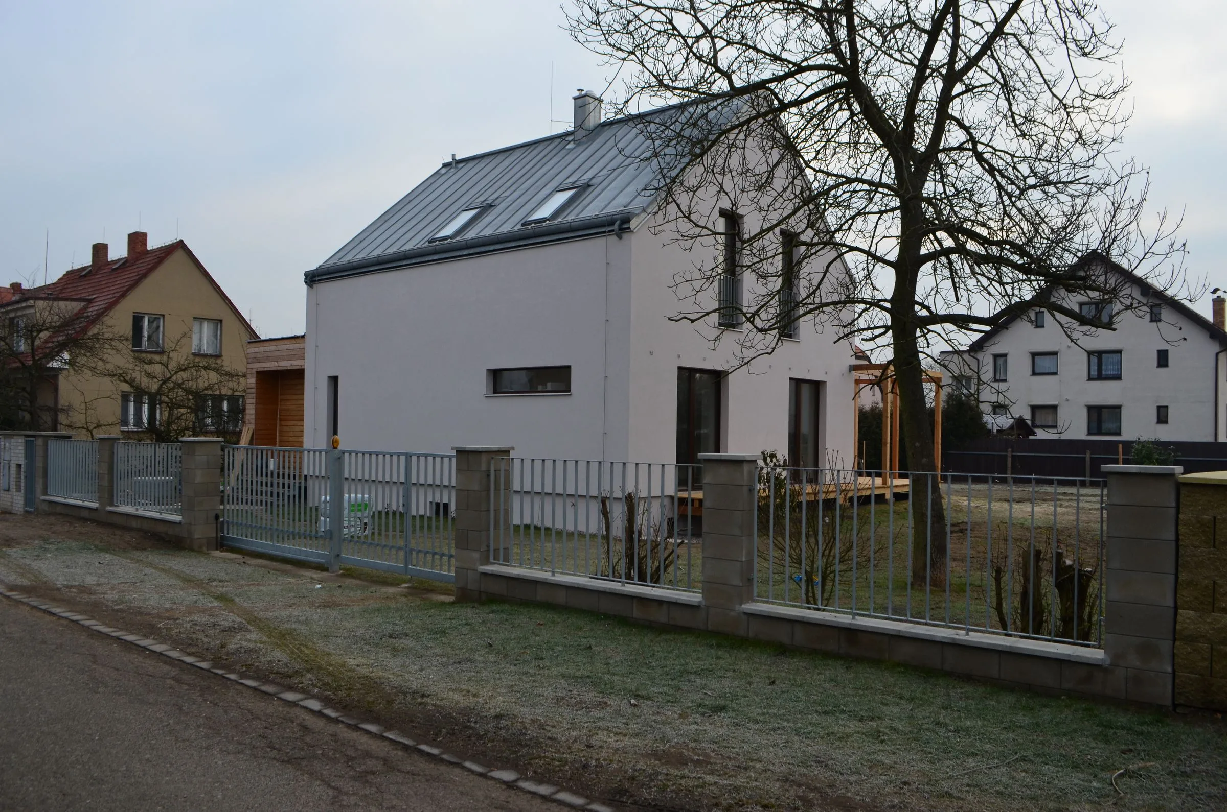Dům po rekonstrukci s&nbsp;bílou fasádou a&nbsp;plechovou střechou