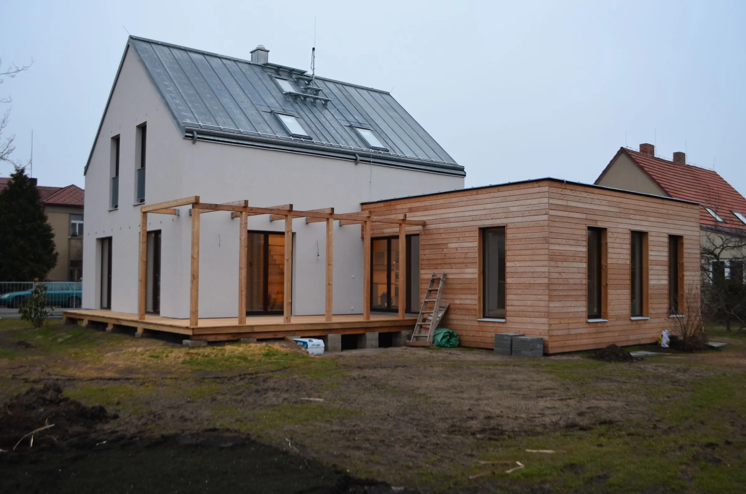 Dům po dokončení s dřevěnou přístavbou a terasou
